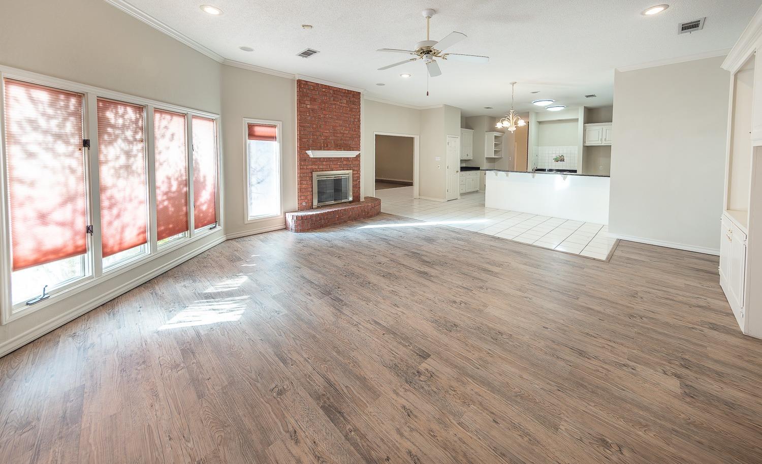 a view of a big room with wooden floor and a kitchen