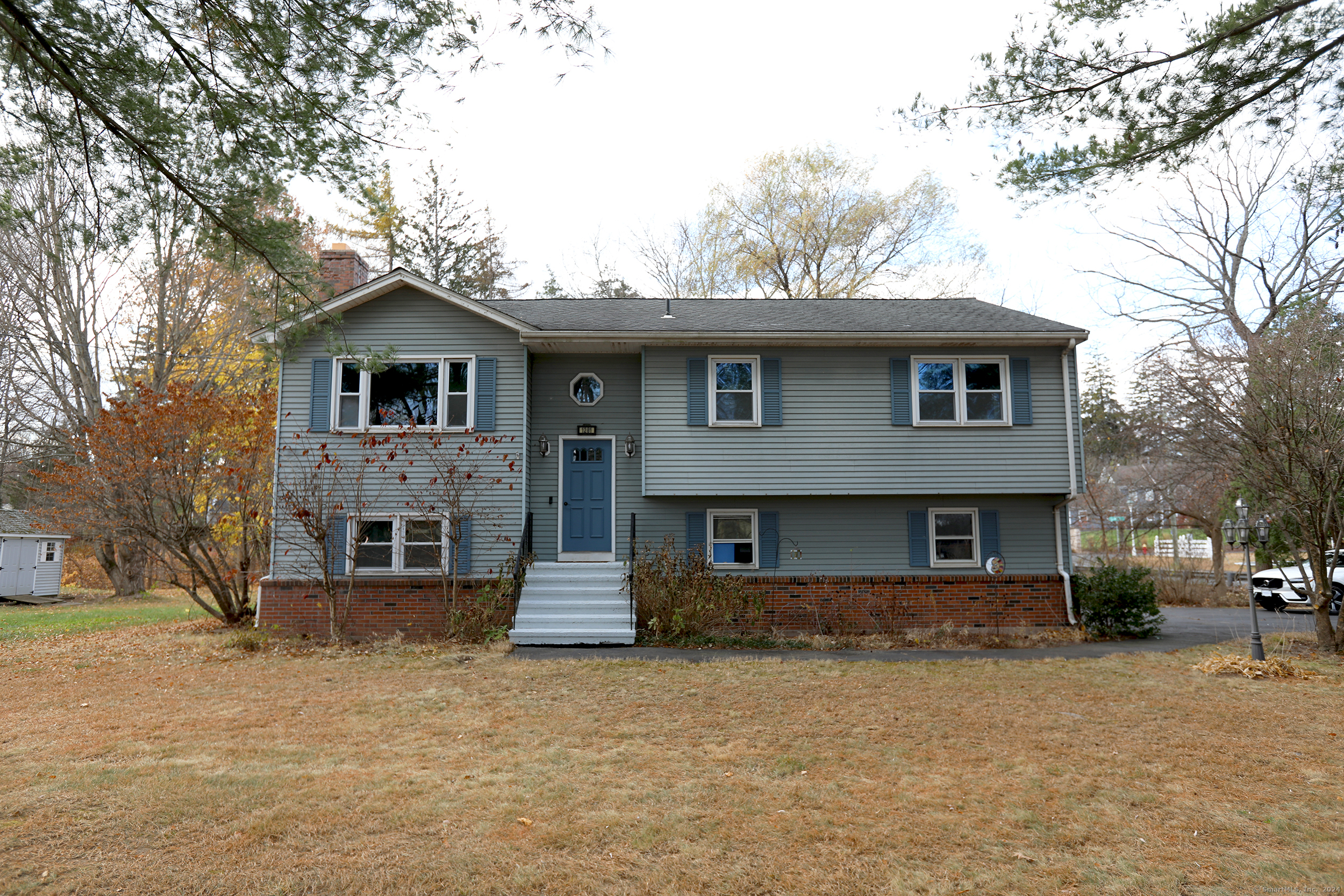 a front view of a house with a tree