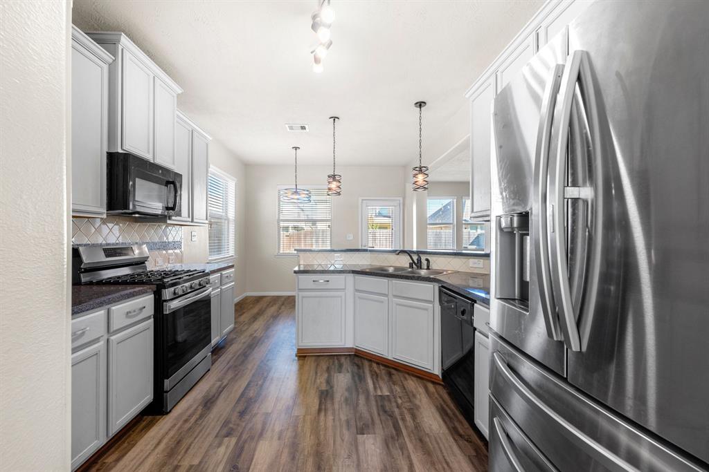 a kitchen with a sink stainless steel appliances and cabinets