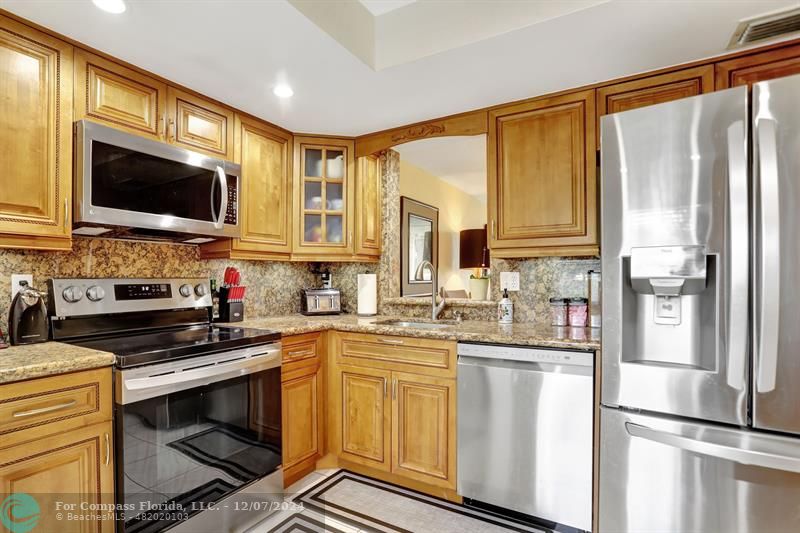 a kitchen with stainless steel appliances a stove microwave and sink