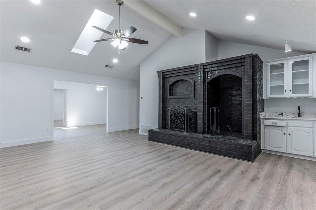 a view of a hallway with wooden floor and a fireplace