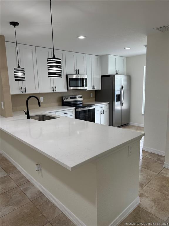 a kitchen with stainless steel appliances a sink a refrigerator a stove a microwave and cabinets