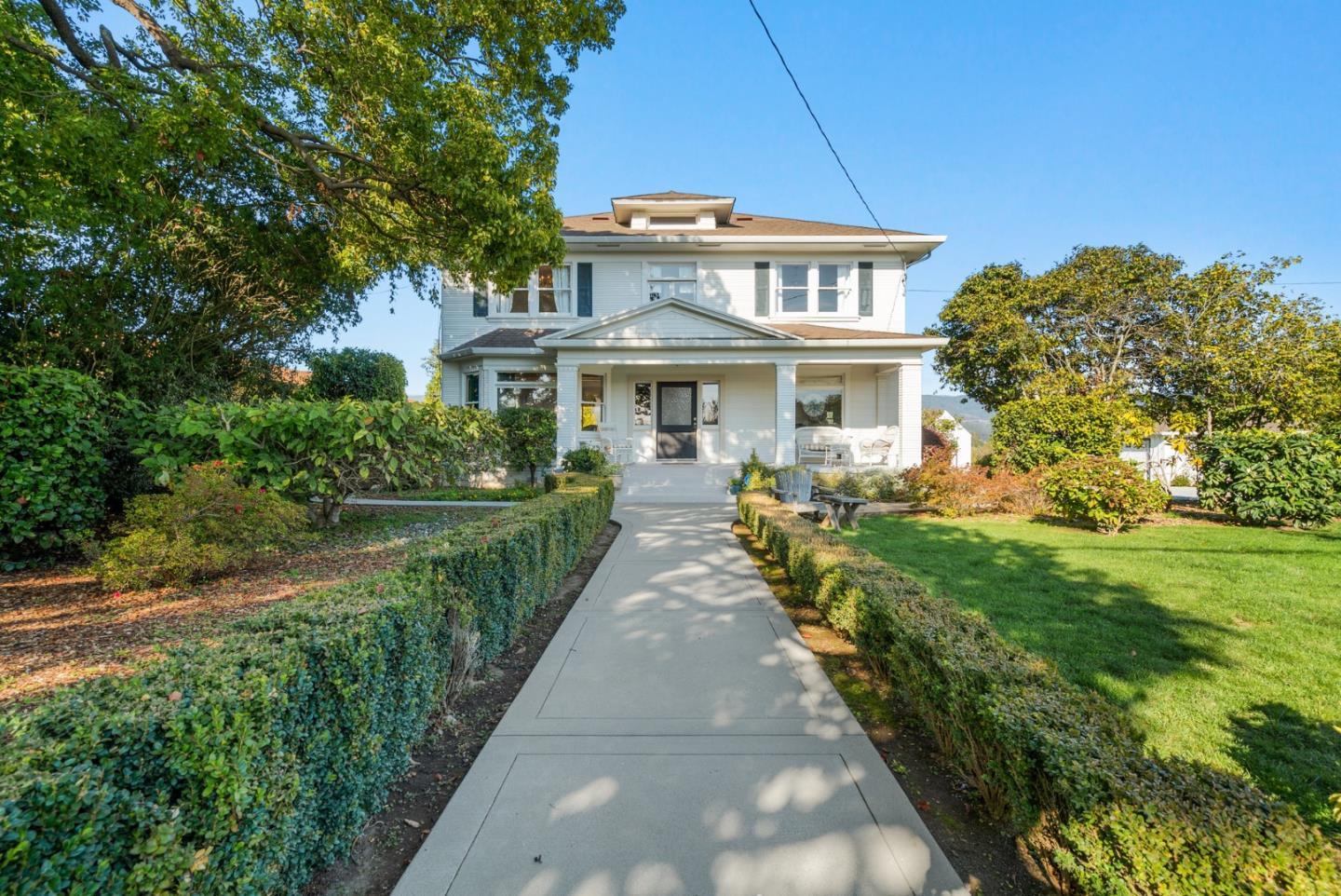 a front view of a house with a garden and plants