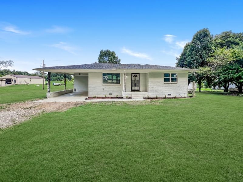 View of front of home featuring a front yard and a carport