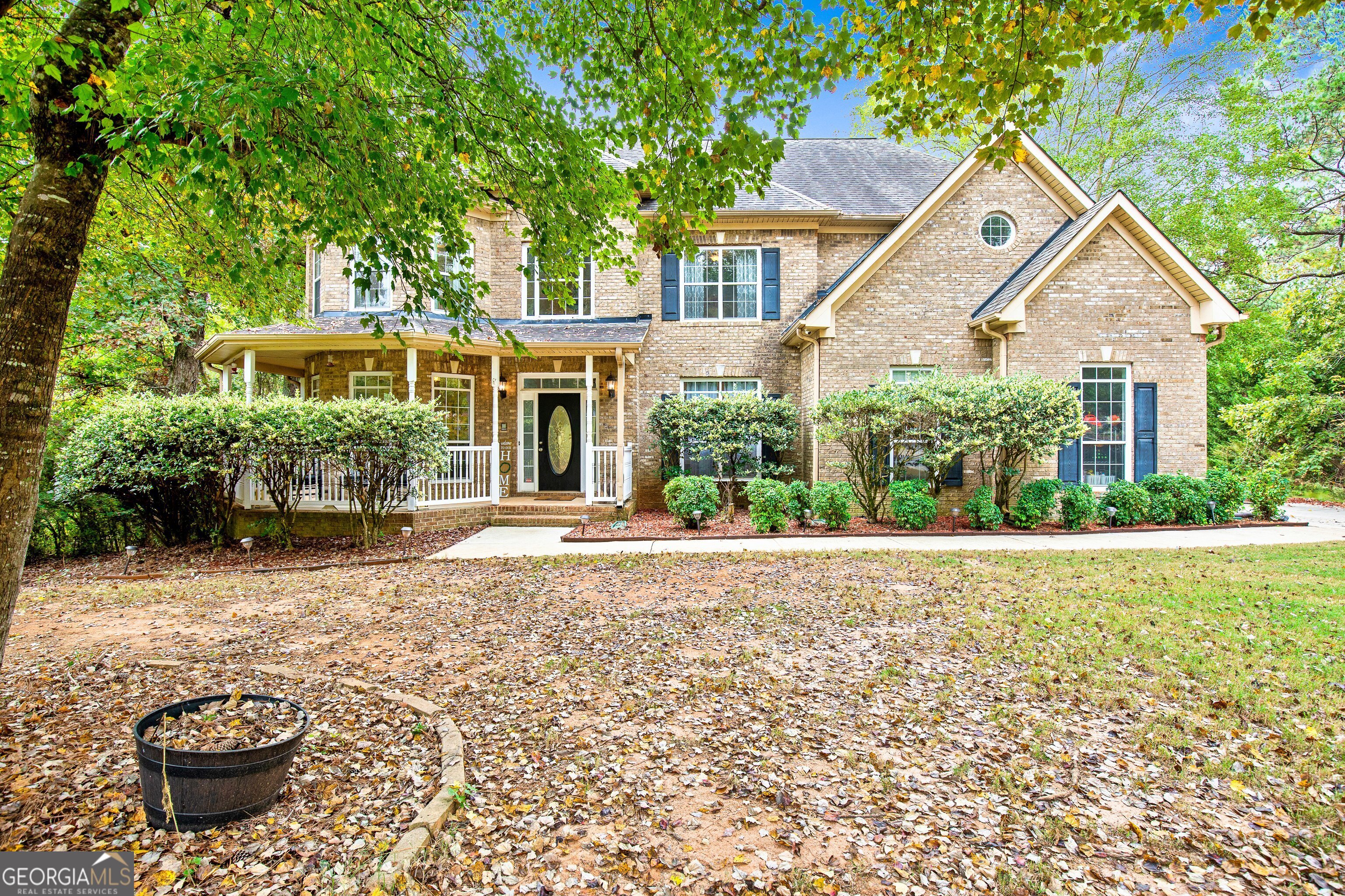 a front view of a house with a yard and potted plants