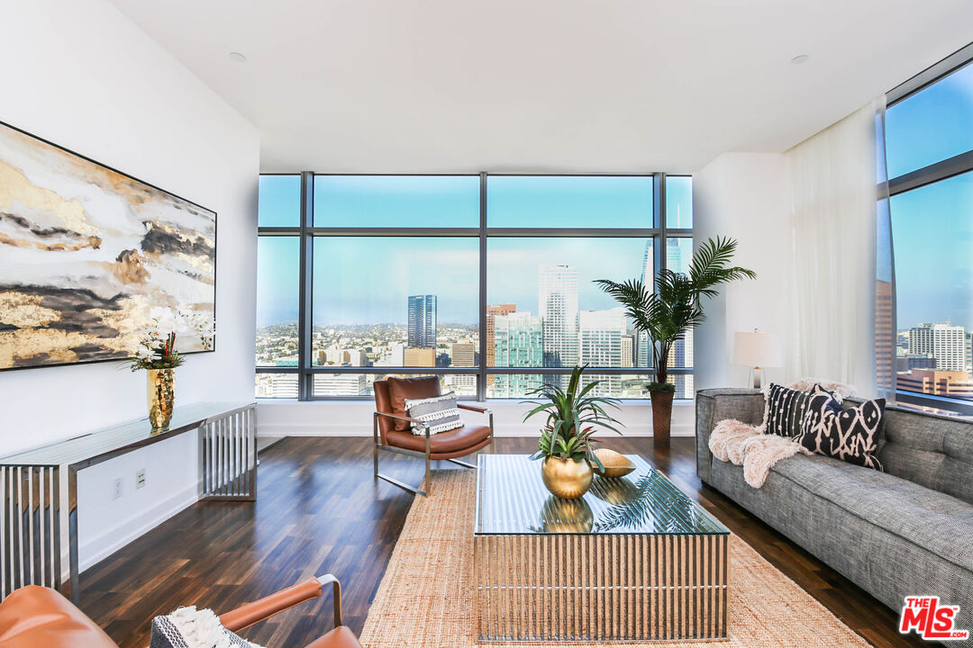 a living room with furniture and a large window with wooden floor