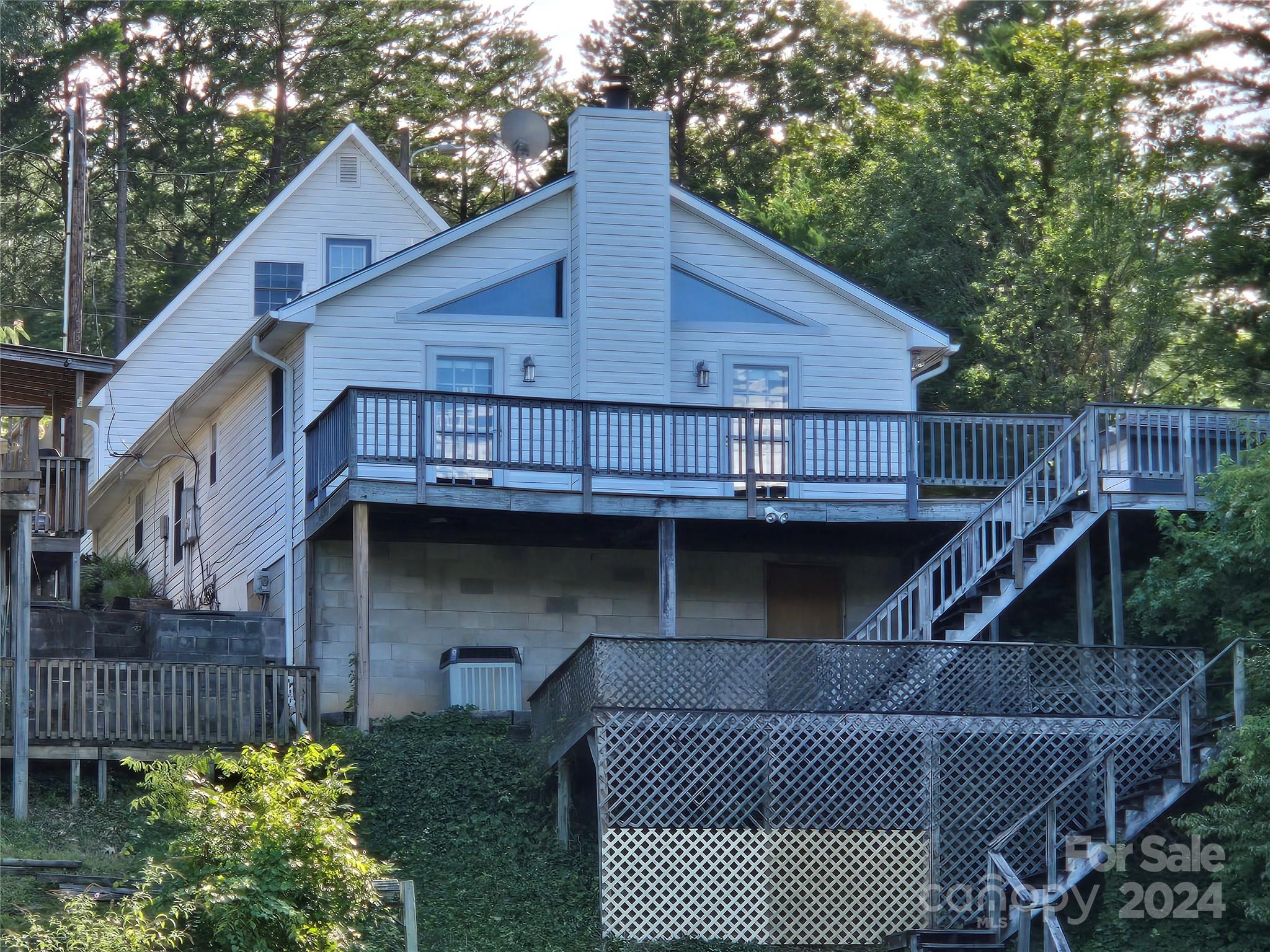 a view of house with a small deck and a wooden bridge