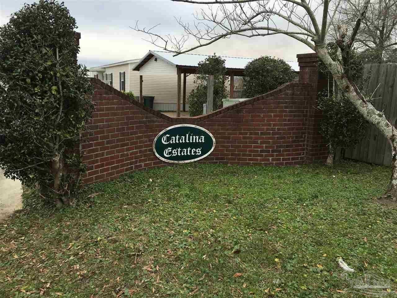 a view of a entrance gate of the house and trees