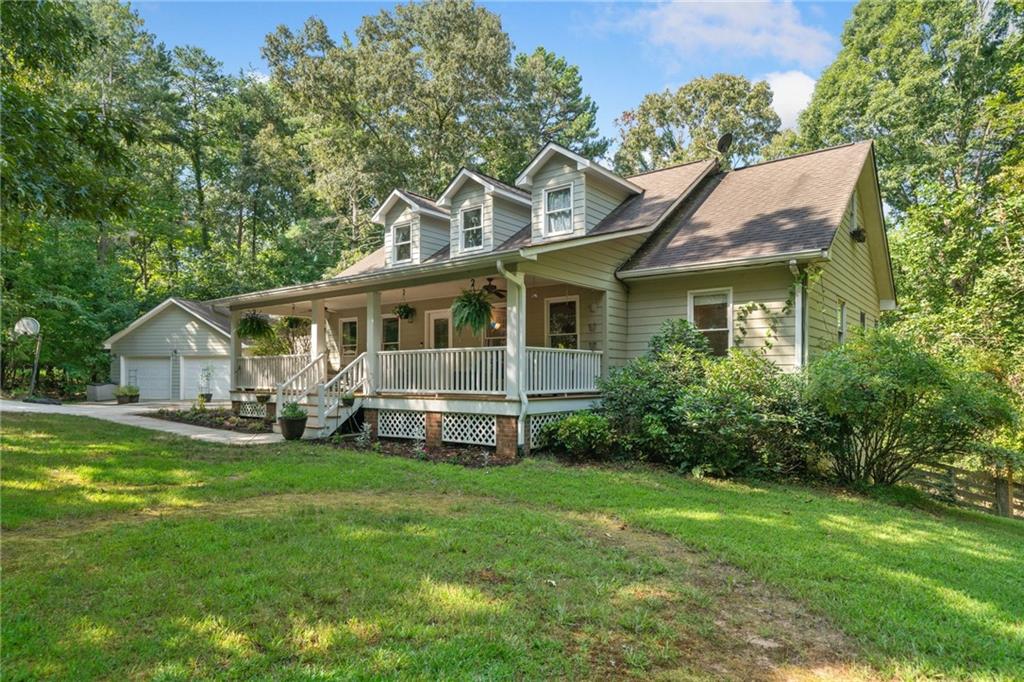 a view of a house with a big yard plants and large trees