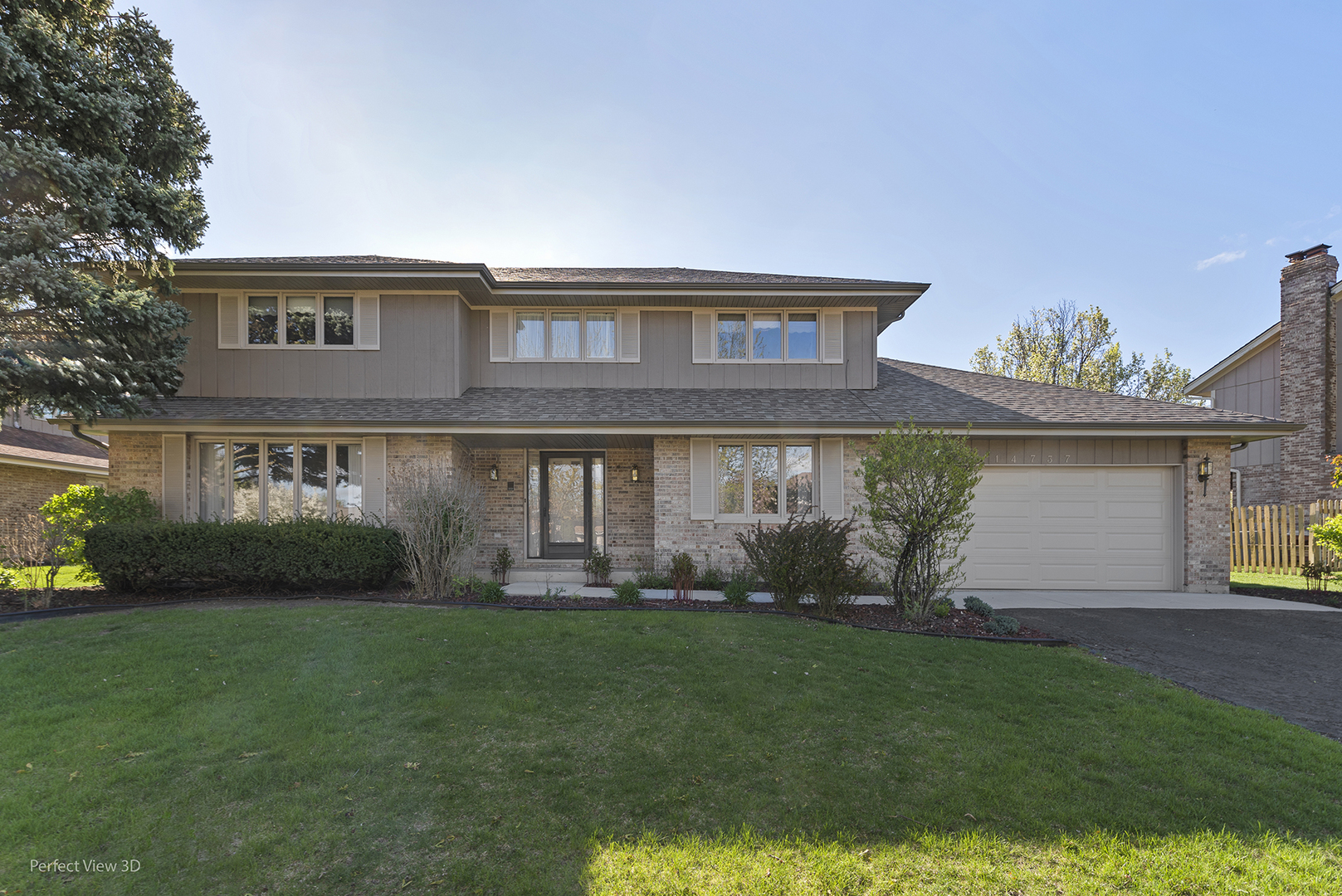 a front view of a house with a garden and yard