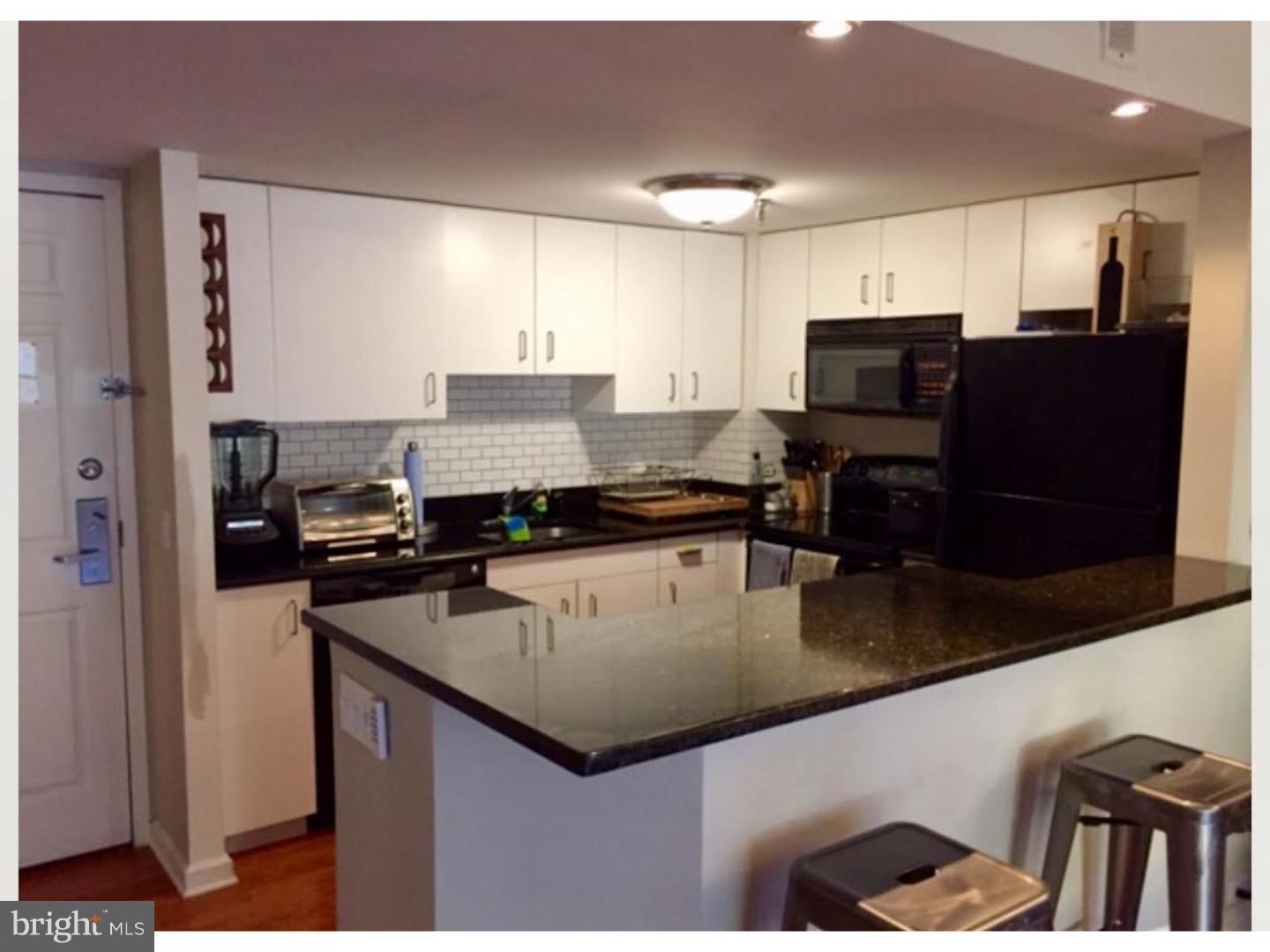 a kitchen with kitchen island granite countertop a sink a counter top space appliances and cabinets