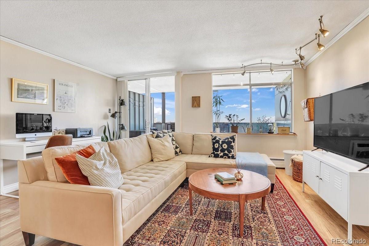 a living room with furniture and a dining table with wooden floor