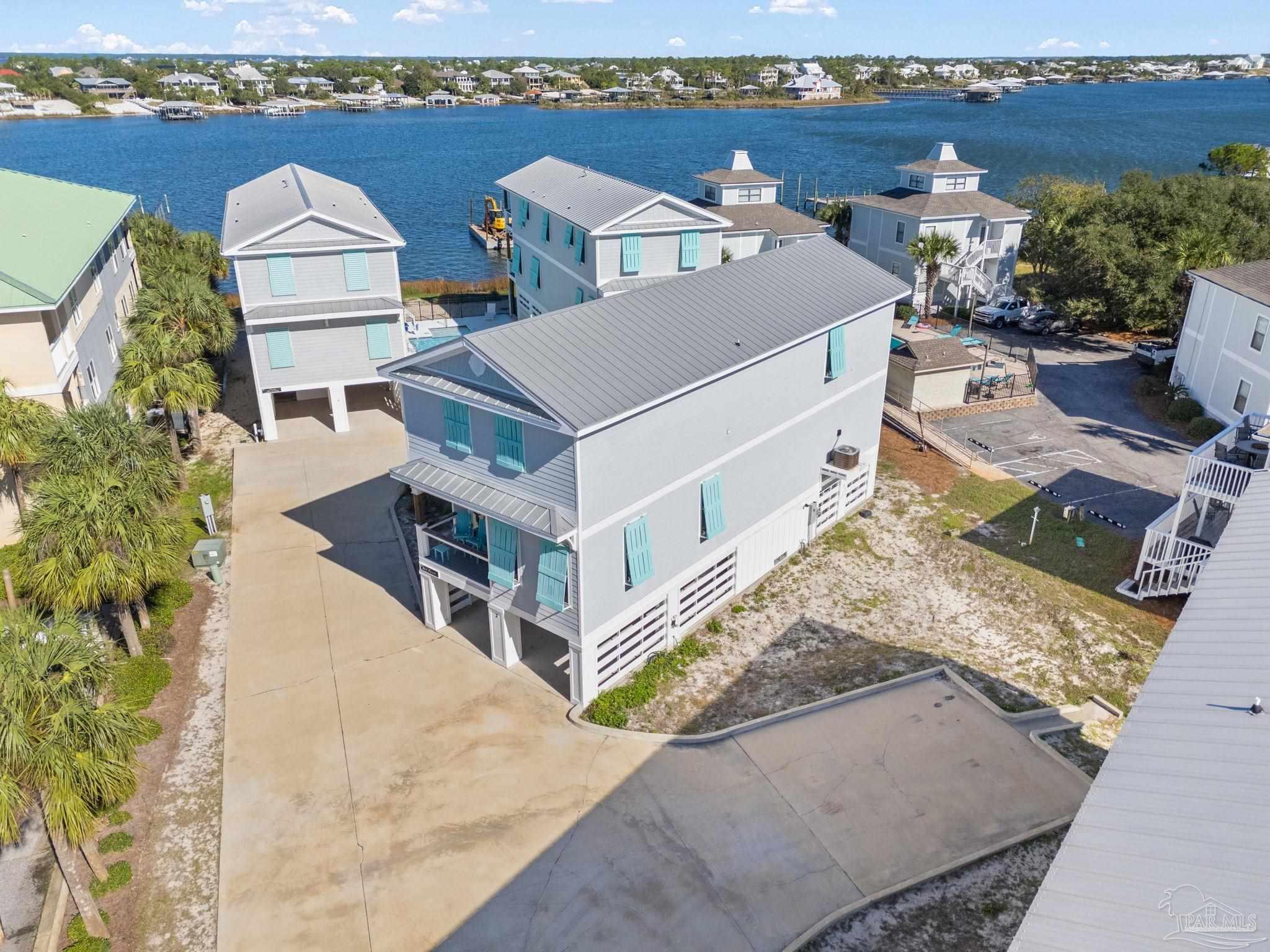 an aerial view of a house with outdoor space and ocean view