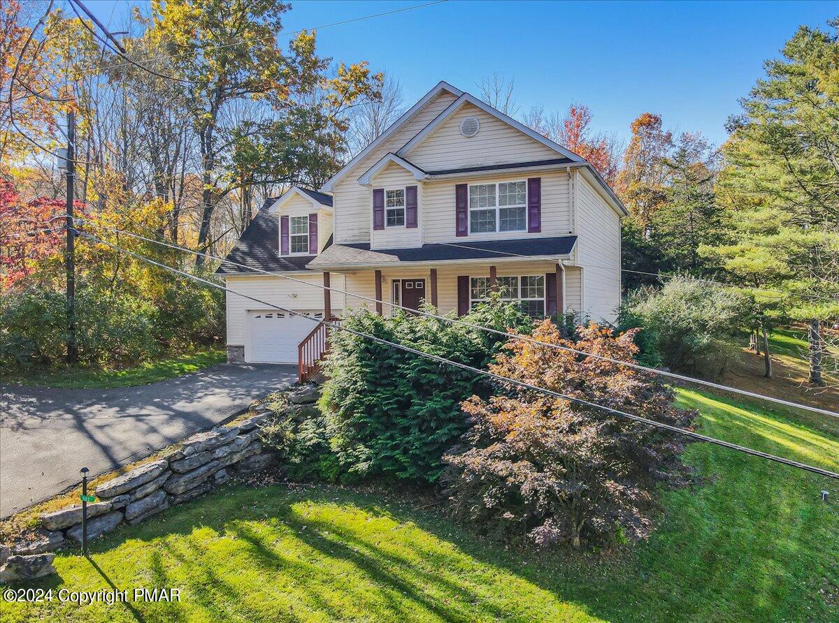 a view of a house with a big yard and large tree