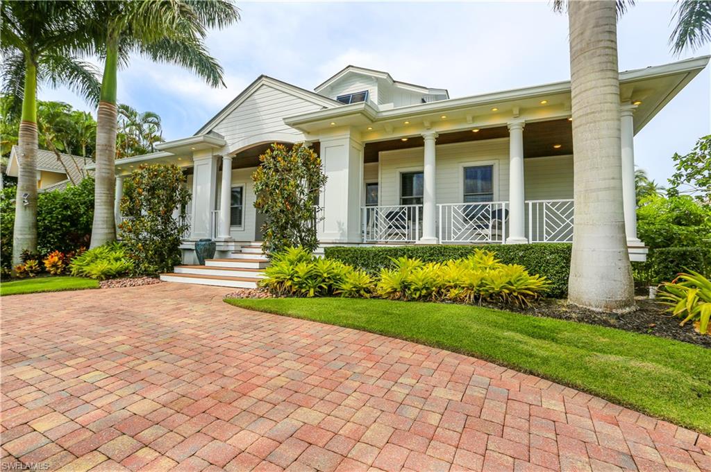 a front view of a house with a yard and potted plants