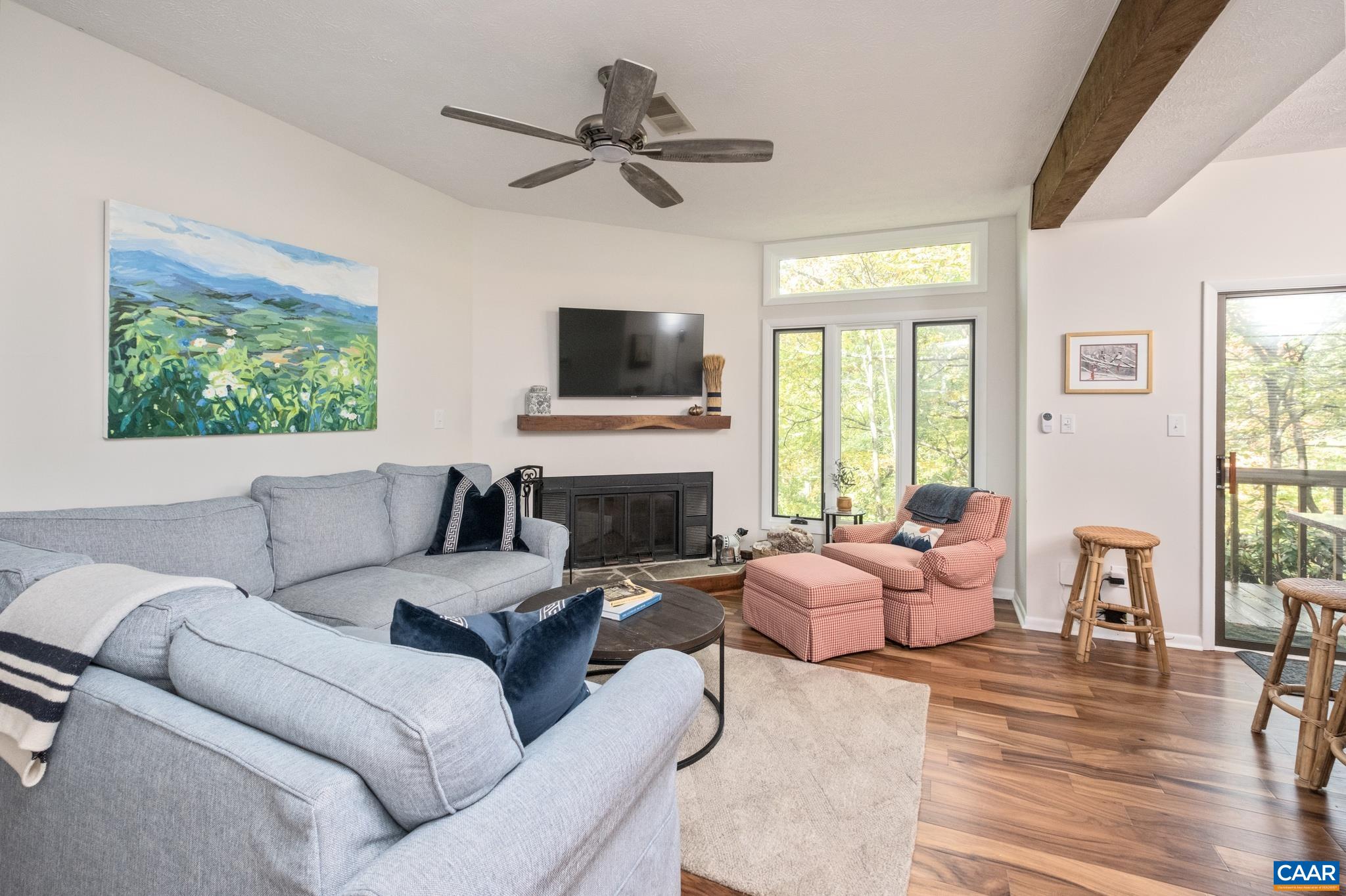 a living room with furniture a fireplace and a flat screen tv