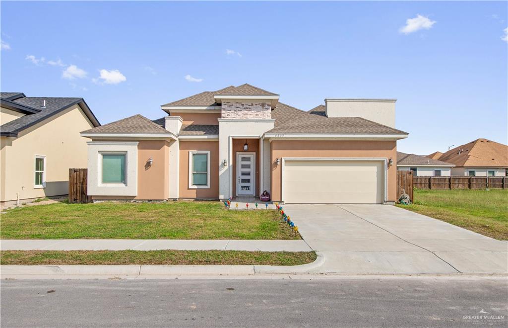 Prairie-style home with a garage and a front lawn