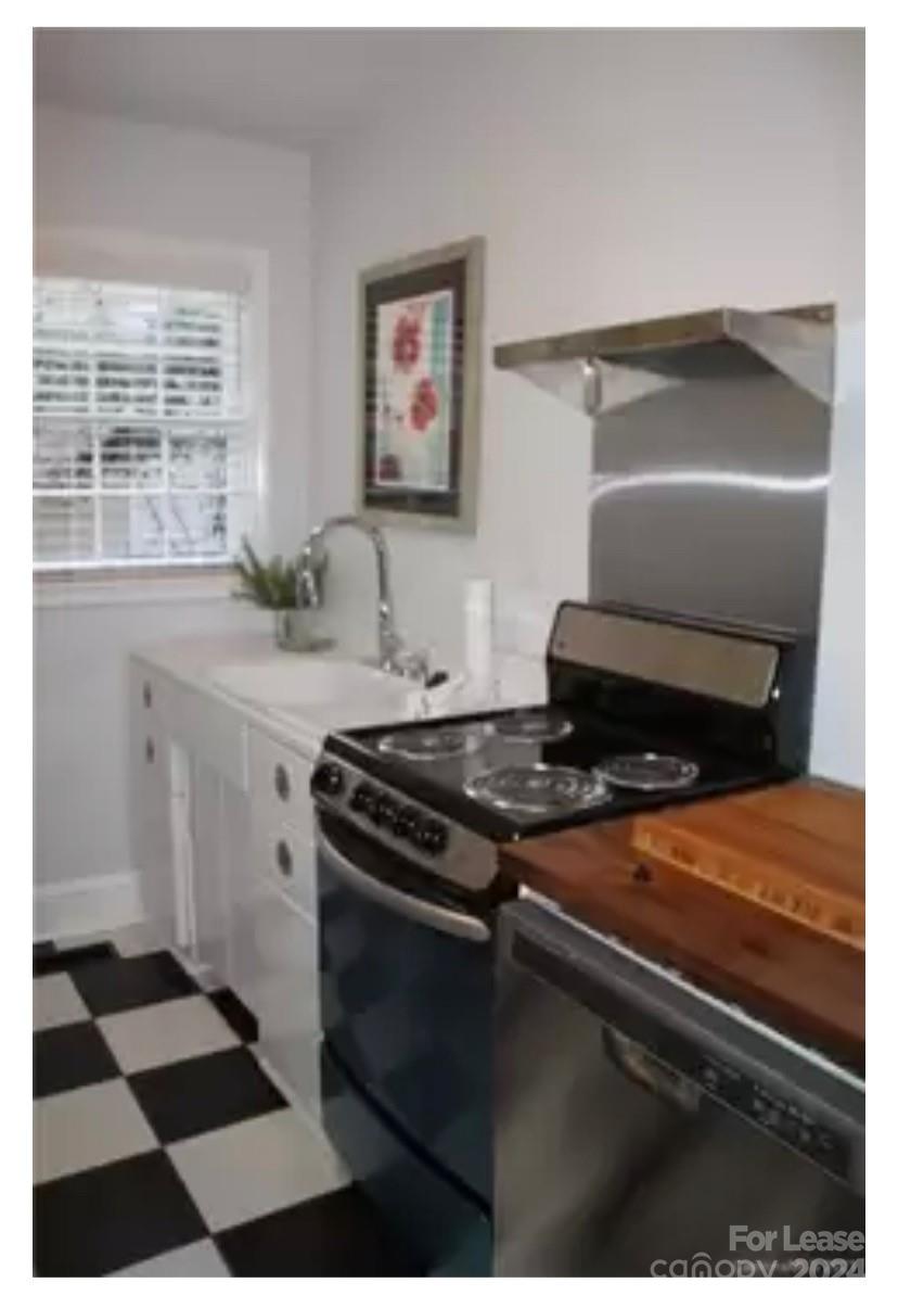 a kitchen with a stove a sink and a window