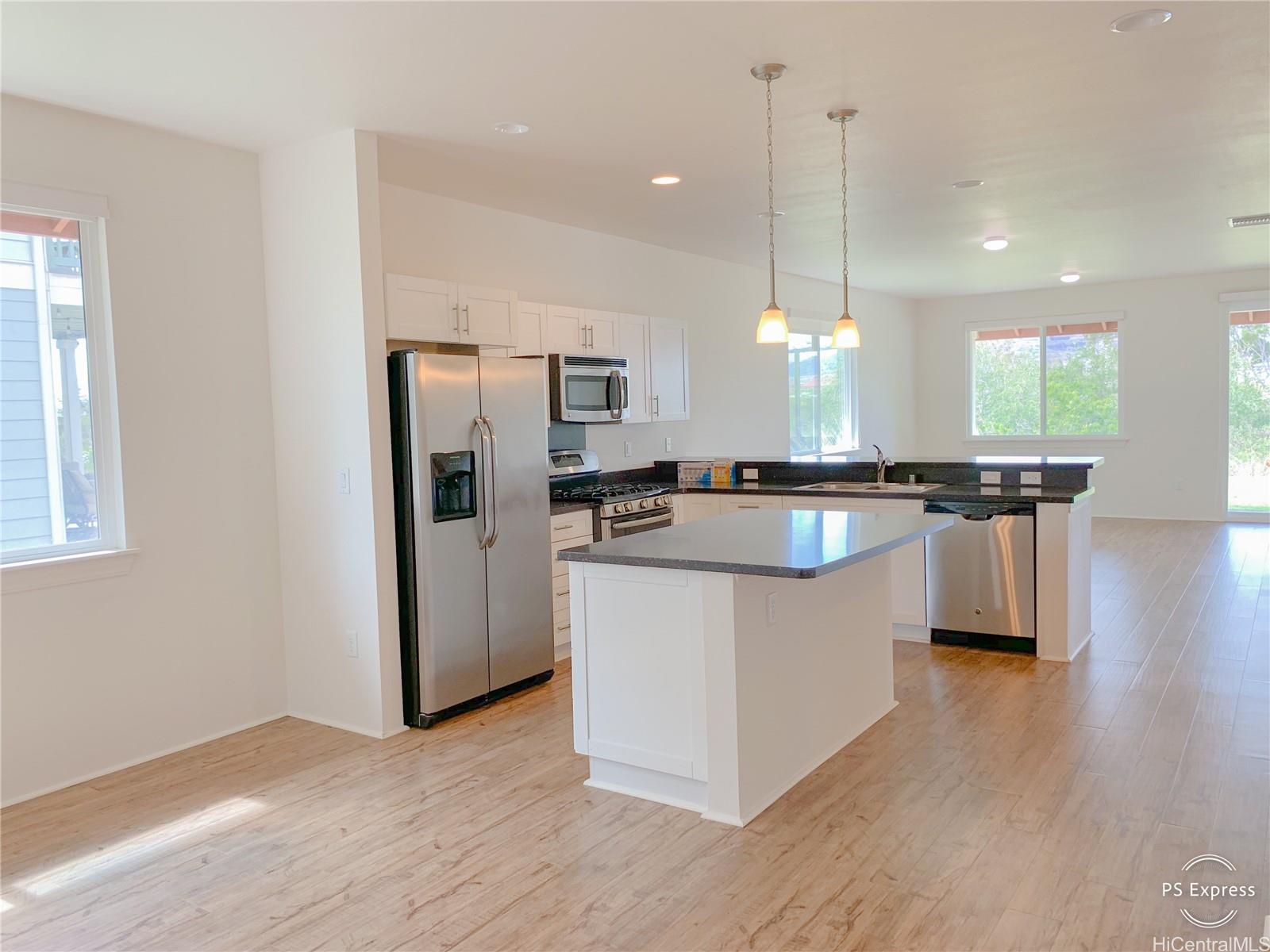 a kitchen with stainless steel appliances granite countertop wooden floors and white cabinets