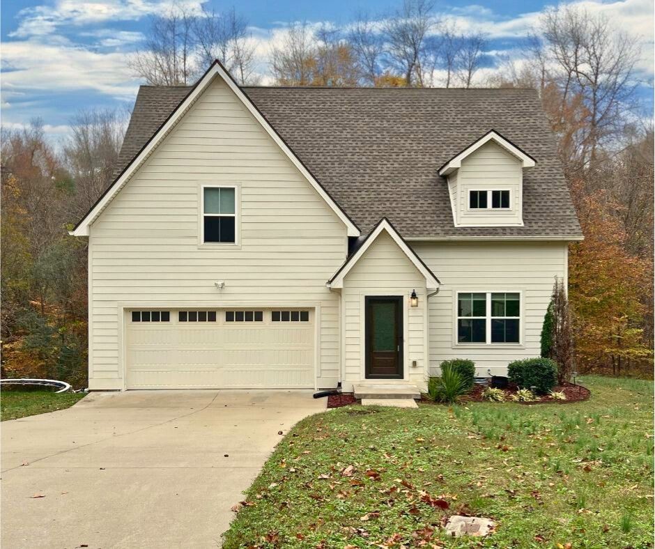 a view of a house with a yard and garage