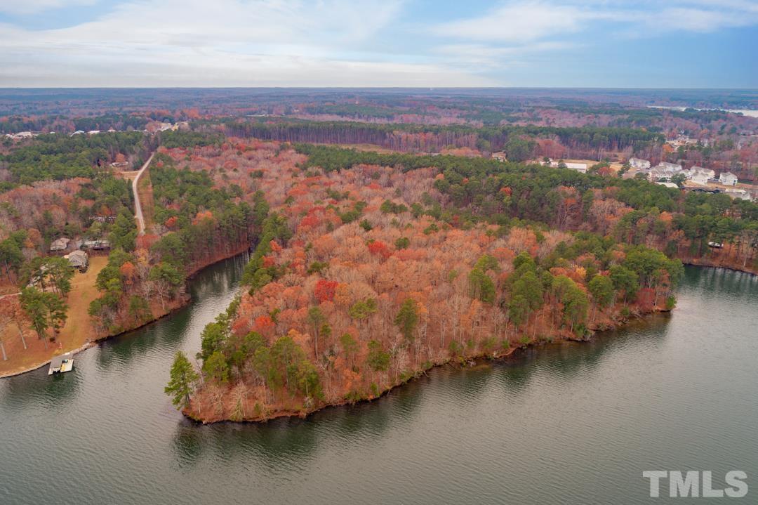 an aerial view of residential houses with outdoor space and lake view