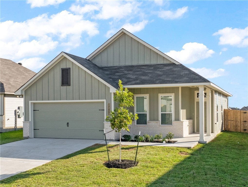 View of front of house with a front lawn and a gar