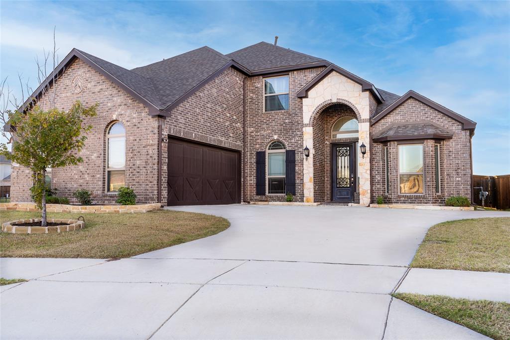 a front view of a house with yard and parking