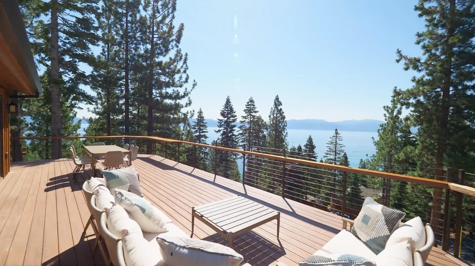 a view of a roof deck with couches and wooden fence