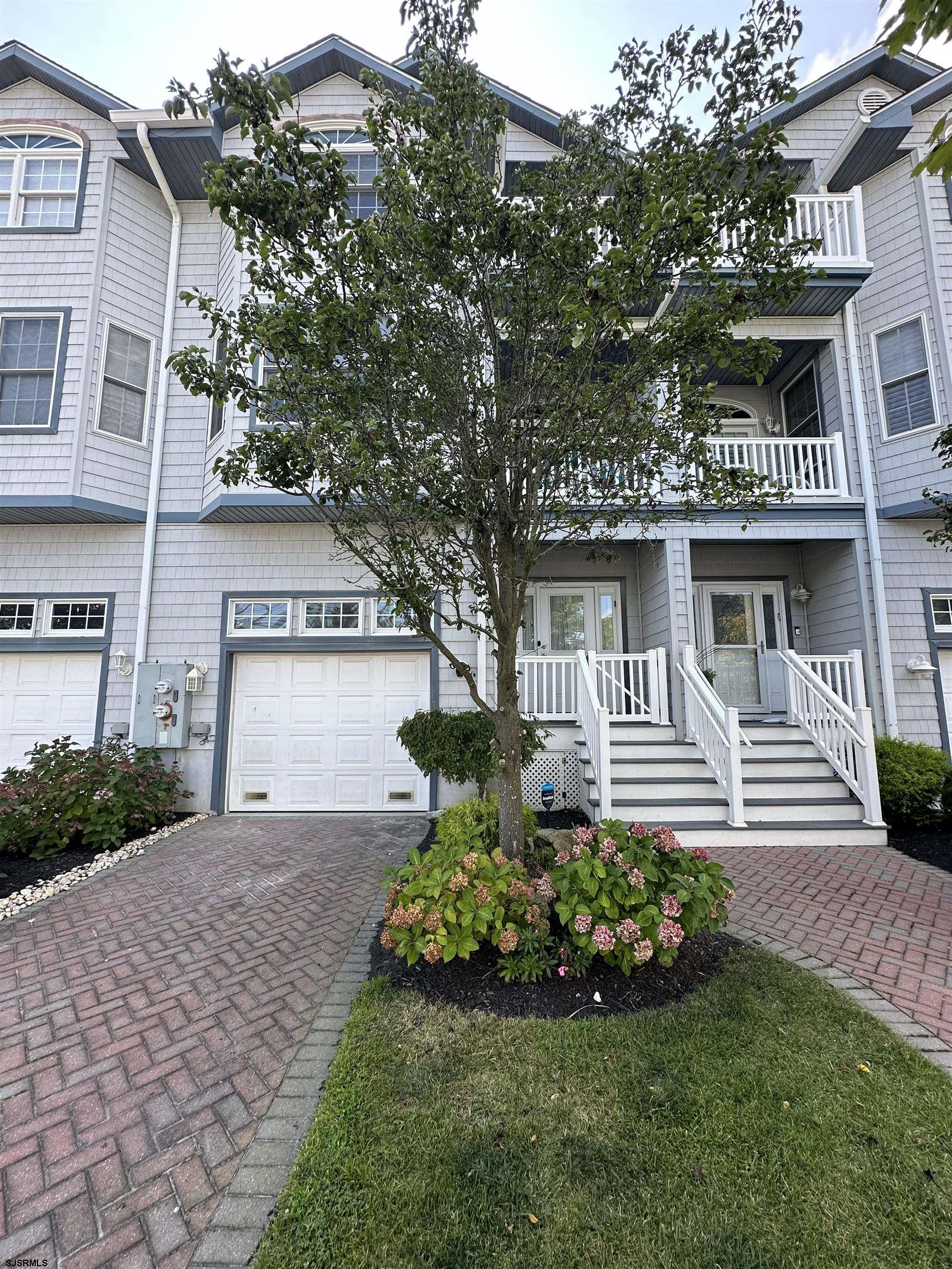 a front view of a house with a yard and garden