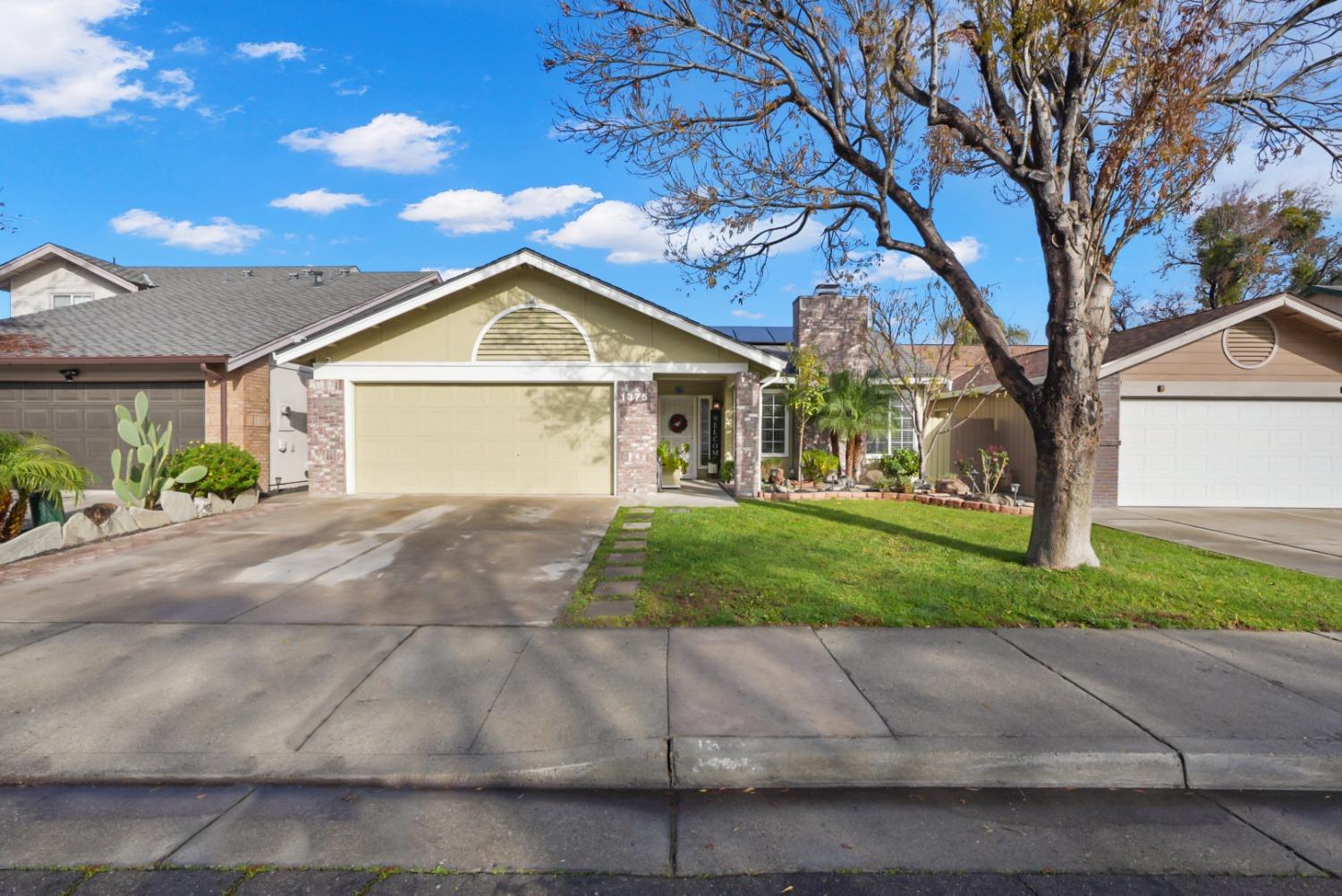 a front view of a house with a yard and a garage