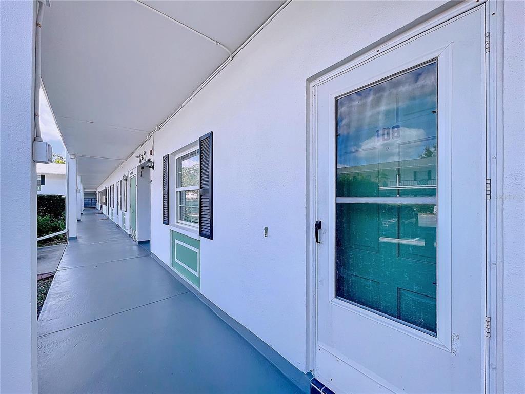 a view of a hallway with furniture and a window