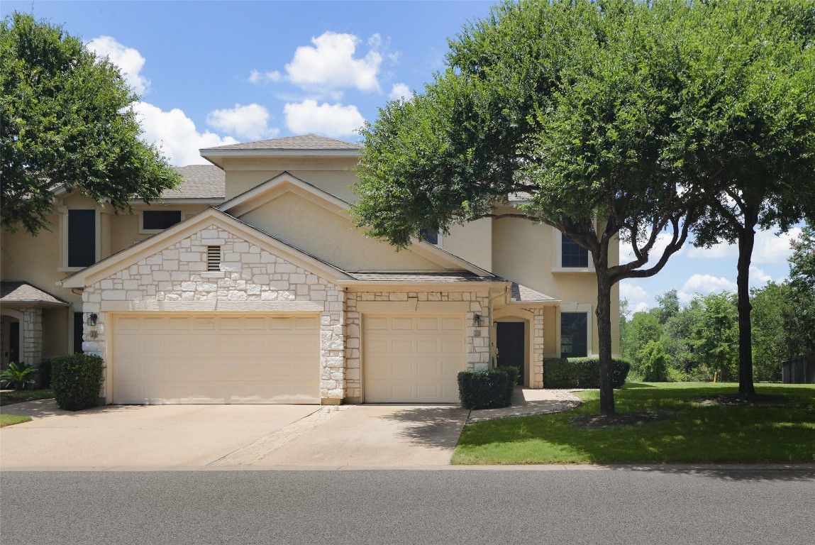 a front view of a house with a yard and garage