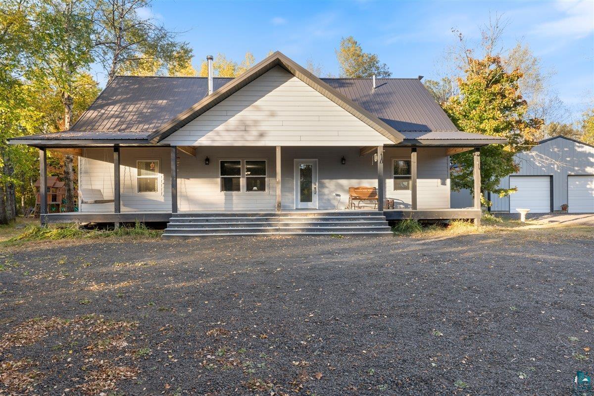 View of front of house featuring an outdoor structure, a garage, and covered porch