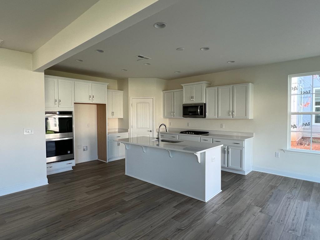 a kitchen with stainless steel appliances a stove top oven a sink and a refrigerator