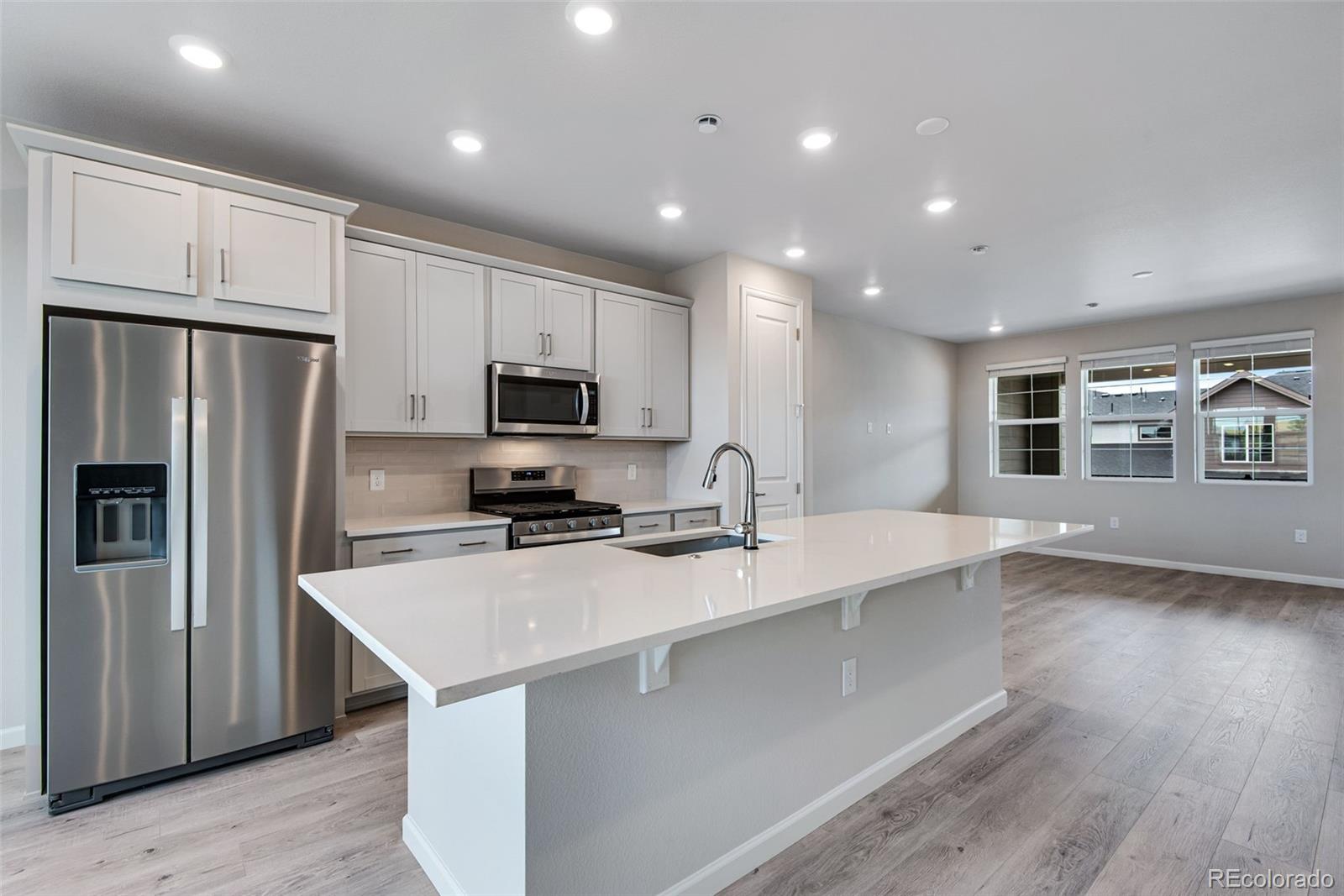 a kitchen with stainless steel appliances a refrigerator sink and microwave