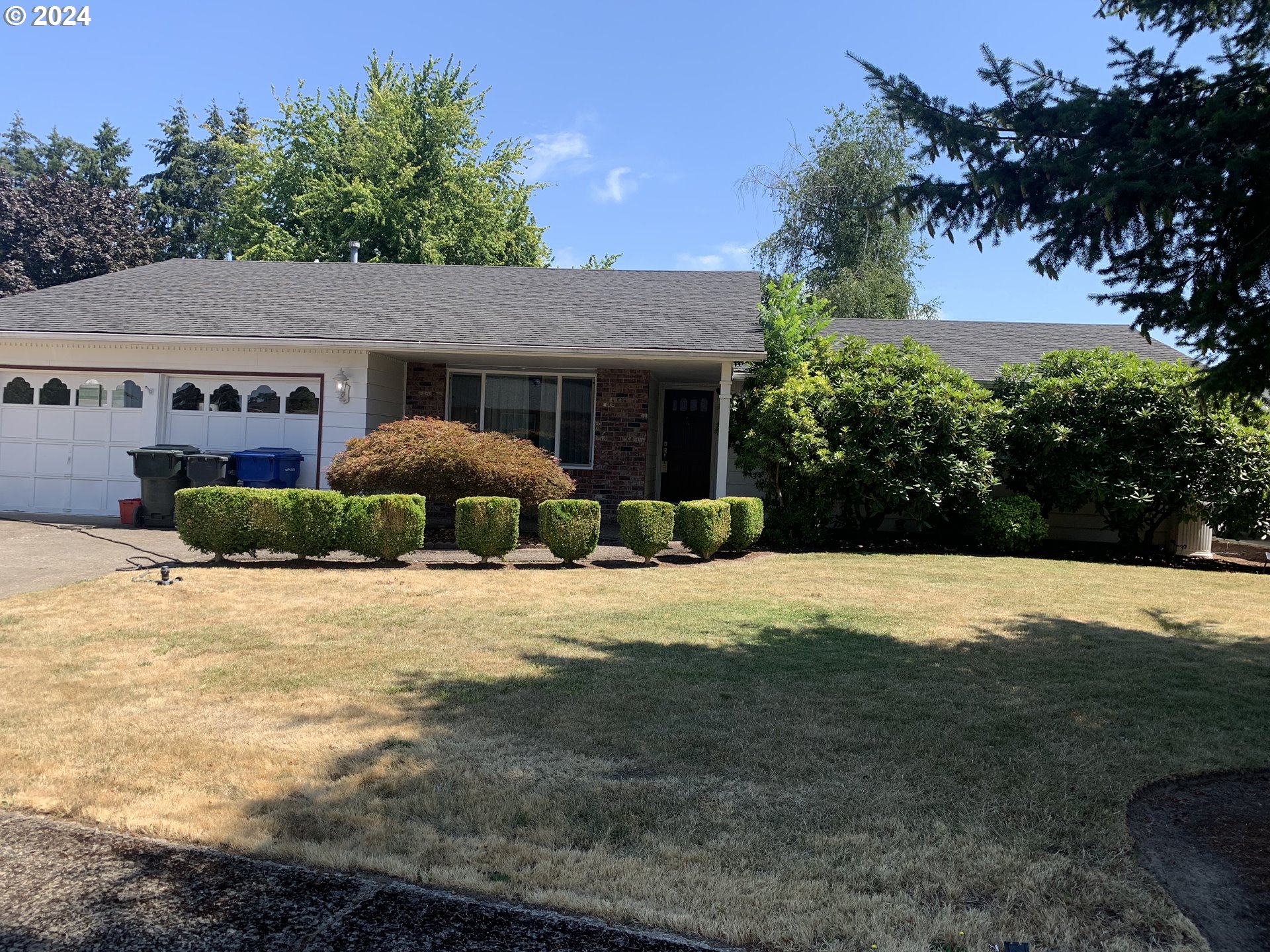 a front view of a house with yard and trees