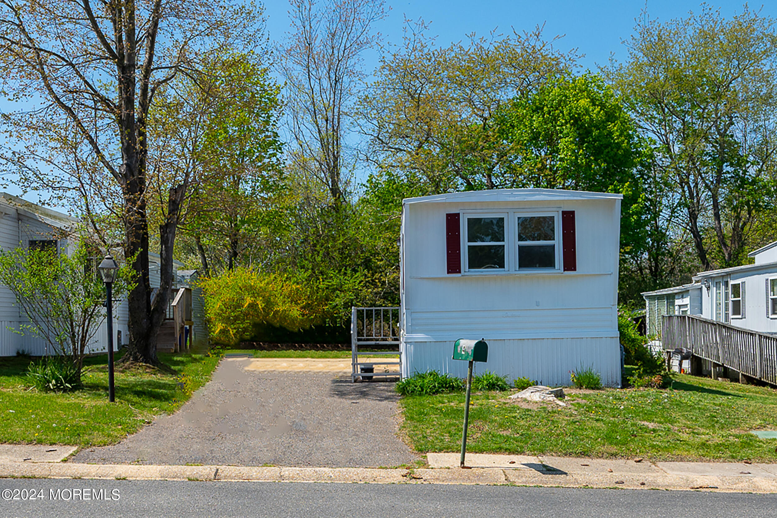 a front view of a house with a garden and tree