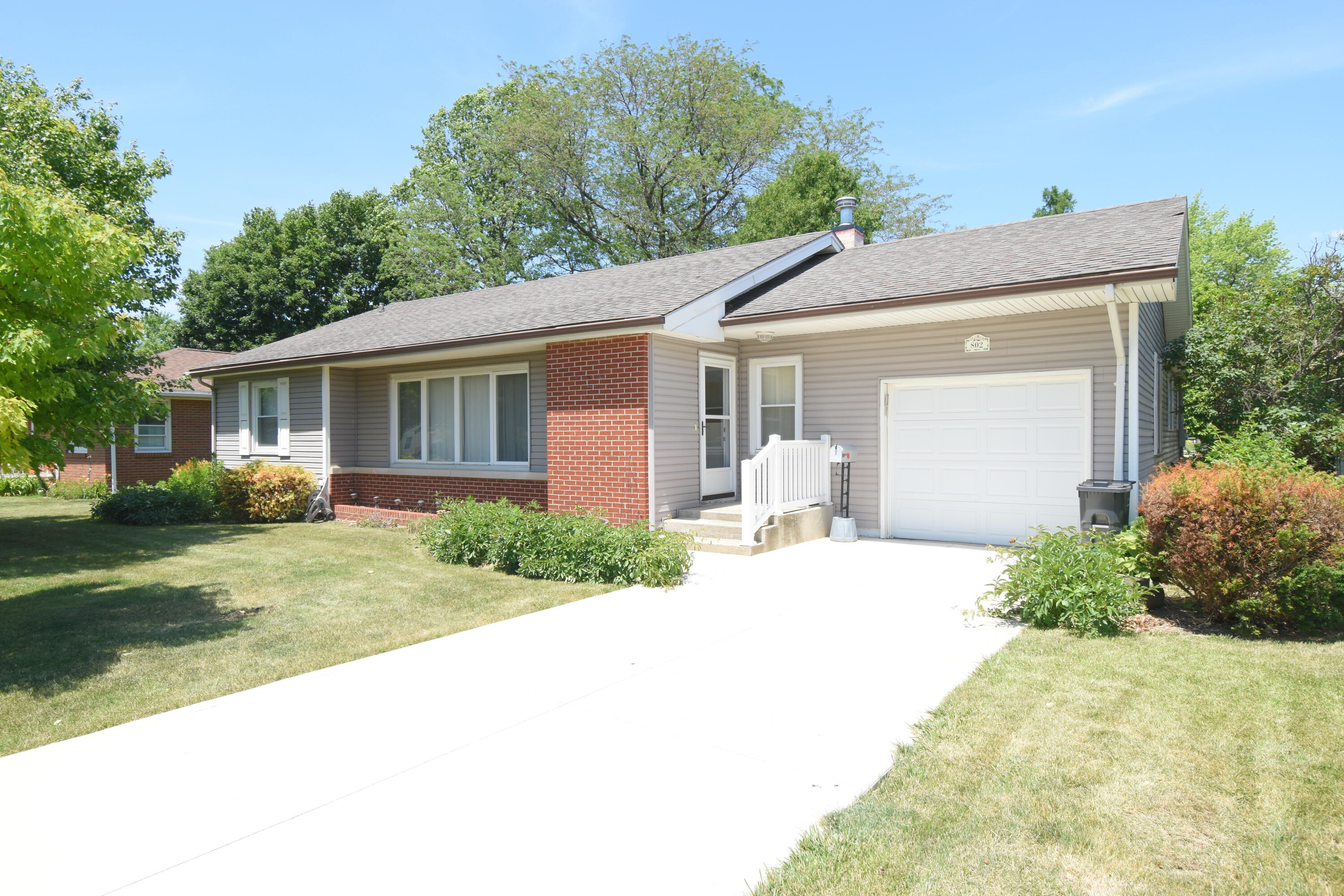 a front view of house with yard and trees around