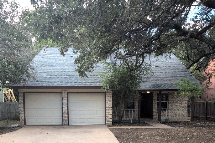 a small house with a tree in front of it