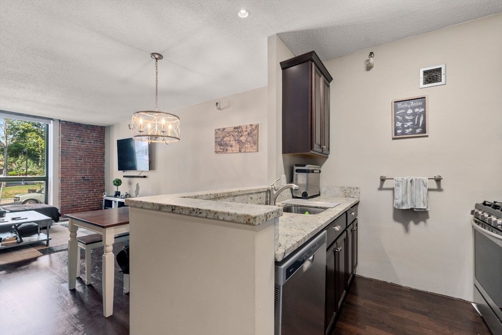 a view of a kitchen counter space a sink wooden floor and a window