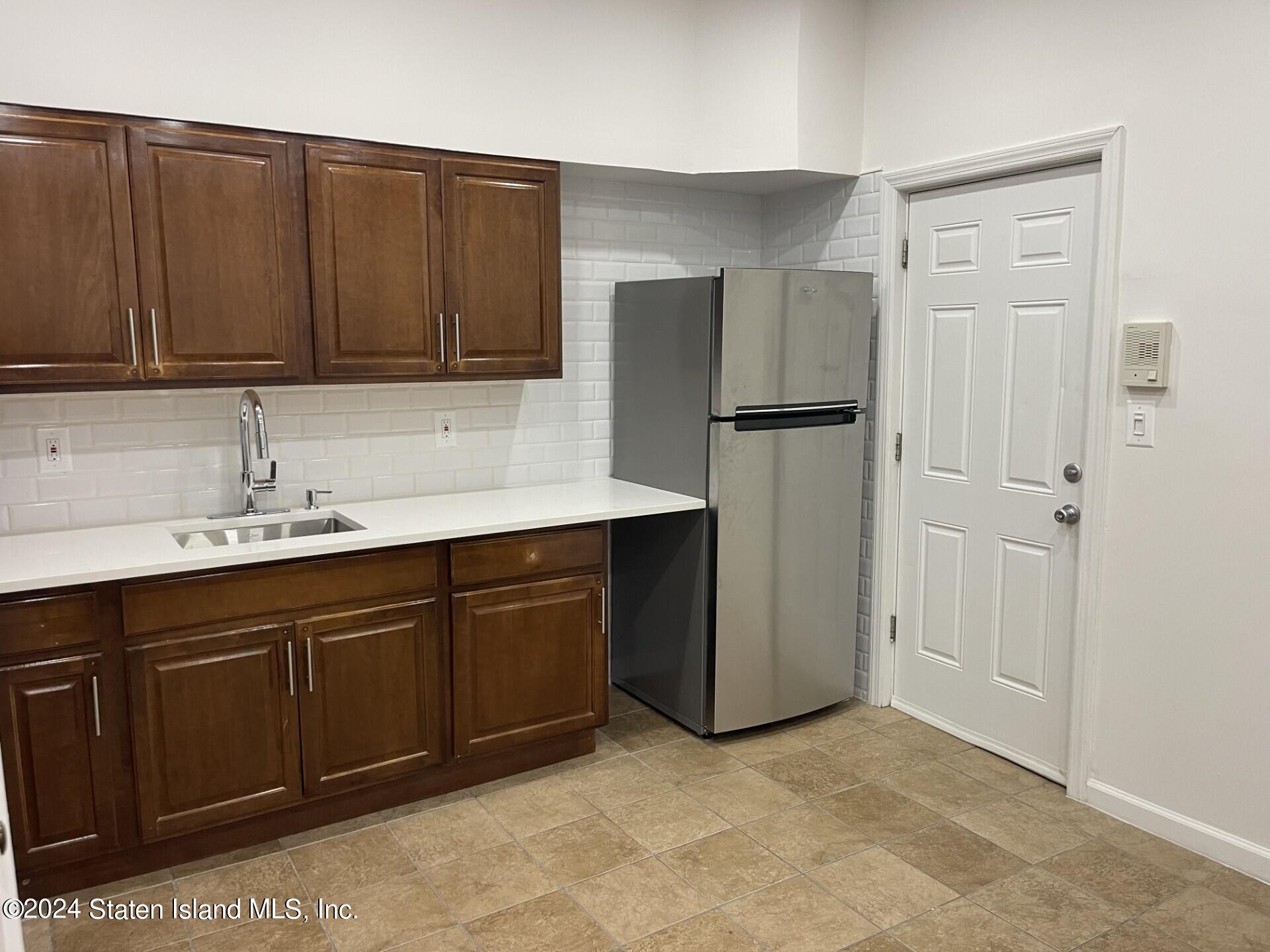 a kitchen with stainless steel appliances granite countertop a refrigerator and a sink