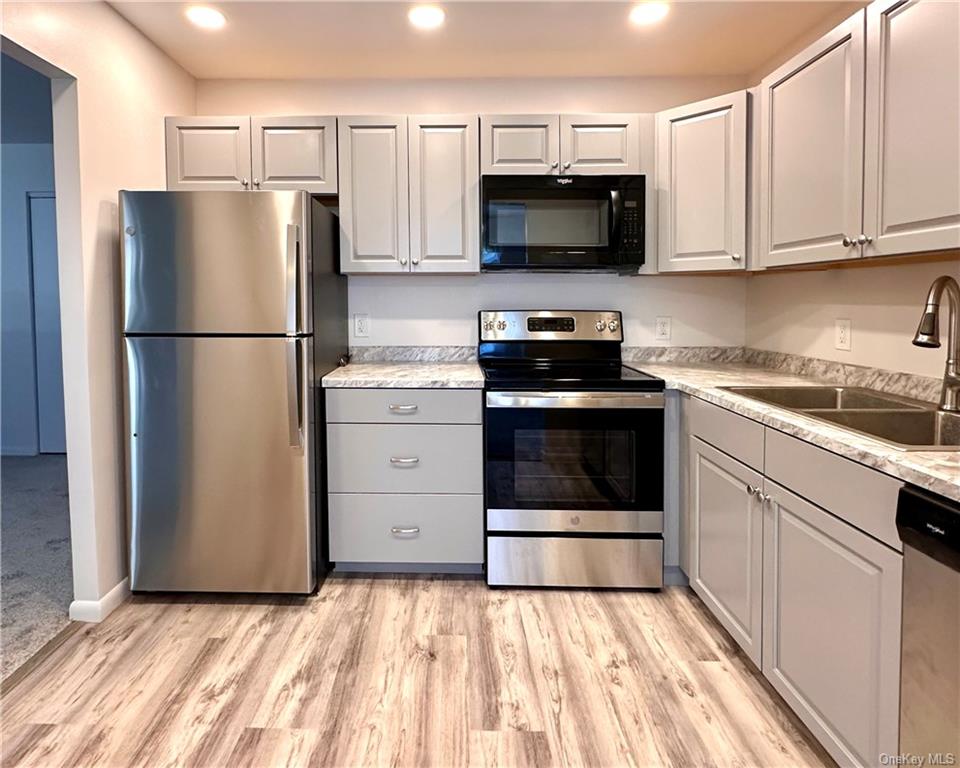 a kitchen with stainless steel appliances a refrigerator stove and microwave