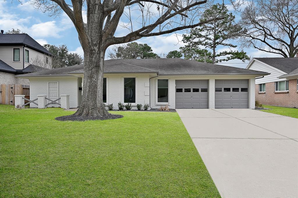 a front view of a house with a garden and trees