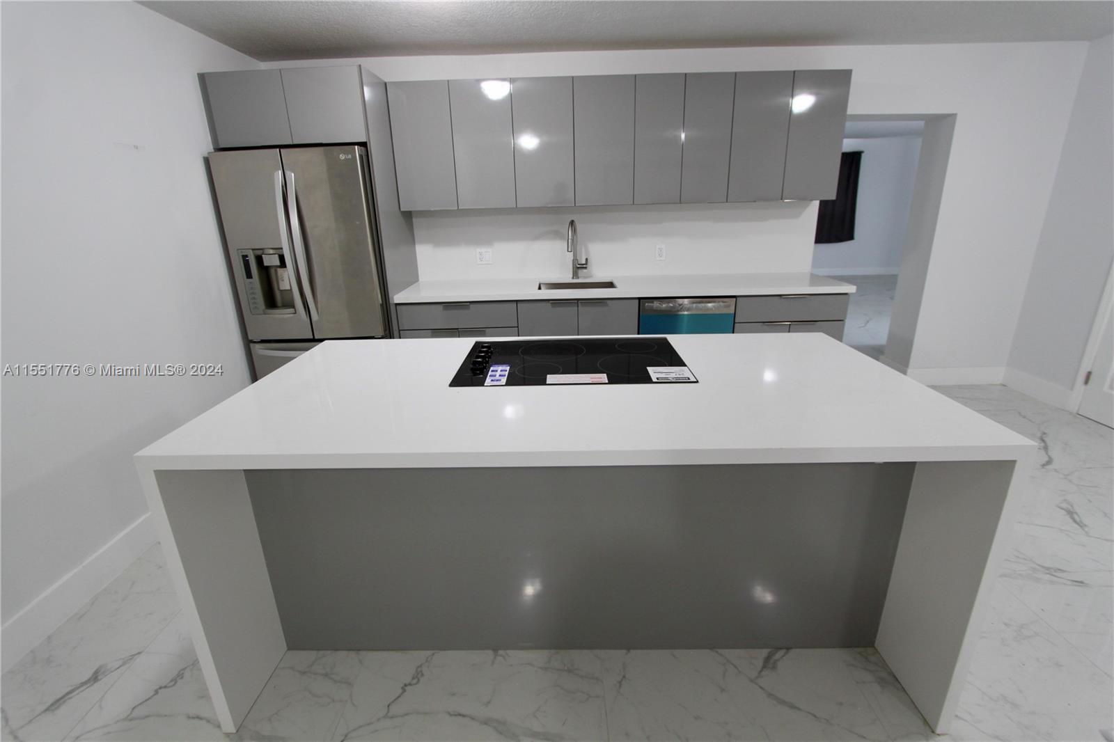 a kitchen with a sink a refrigerator and wooden cabinets