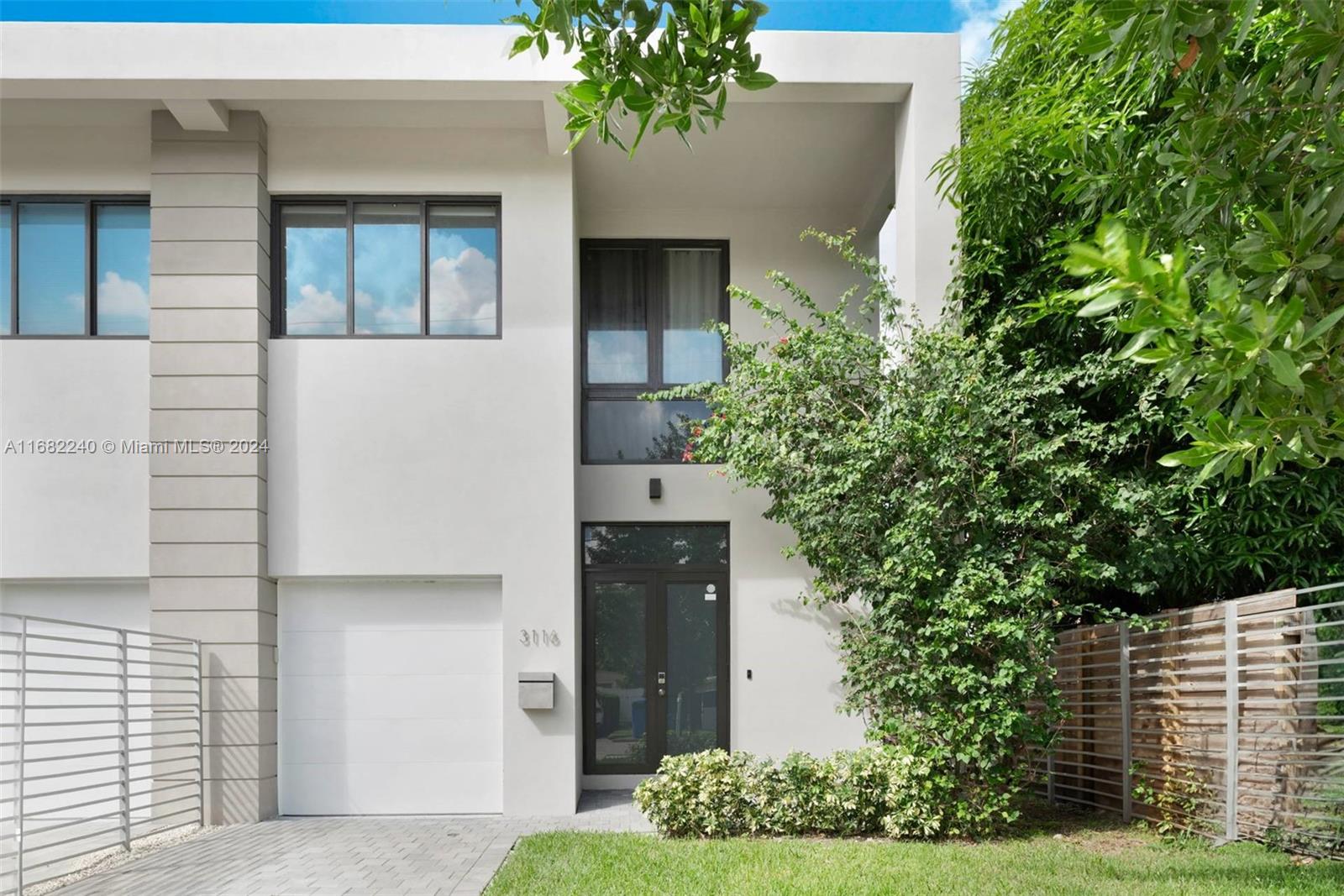 a front view of a house with plants