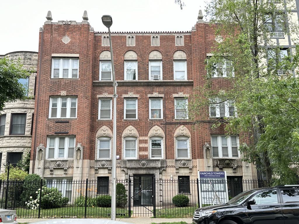 a front view of a residential apartment building with a yard