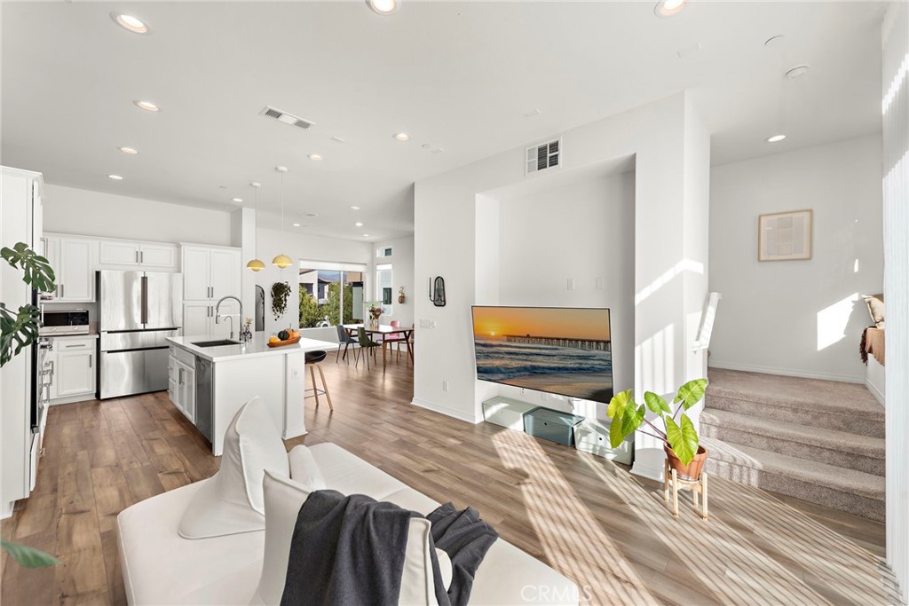 a living room with furniture a flat screen tv and a table