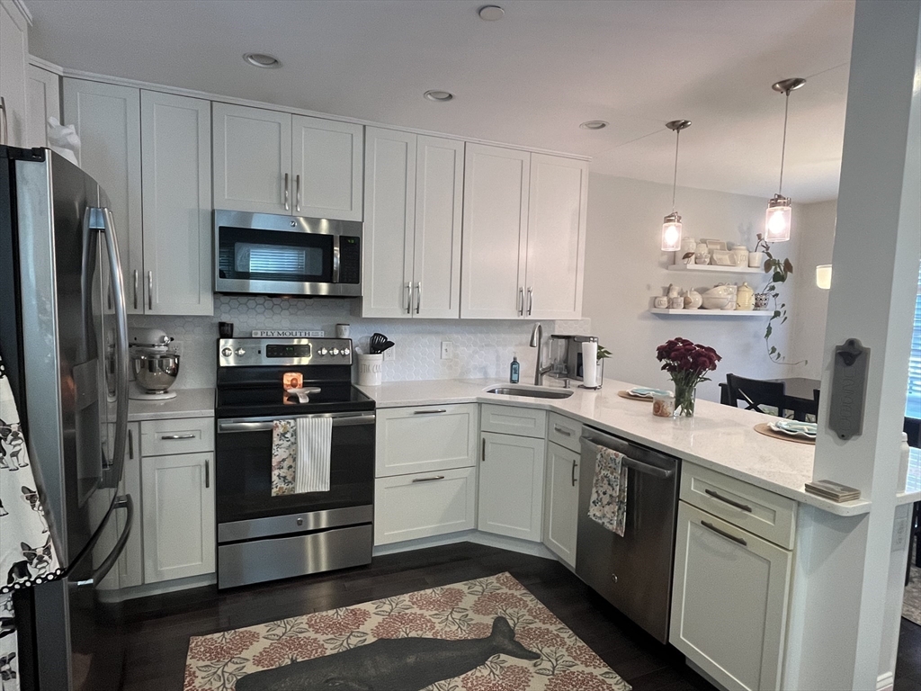 a kitchen with a sink stainless steel appliances and white cabinets