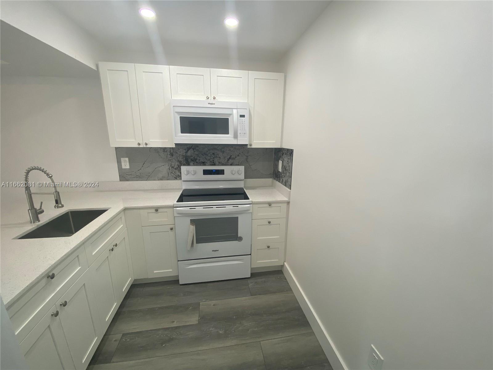 a white kitchen with white stainless steel appliances