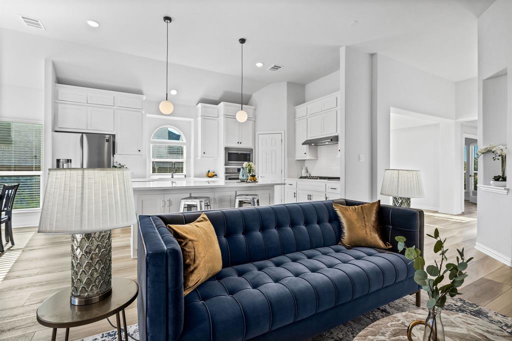 a living room with furniture kitchen and a chandelier